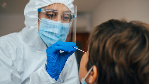 Fachpersonal testet Person mit Antigen-Schnelltest