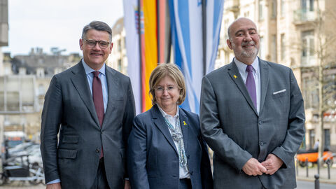 Boris Rhein, Talya Lador-Fresher und Ron Prosor stehen vor Flaggen