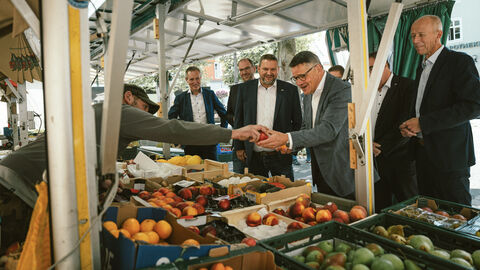 Mehrere Männer an Obststand