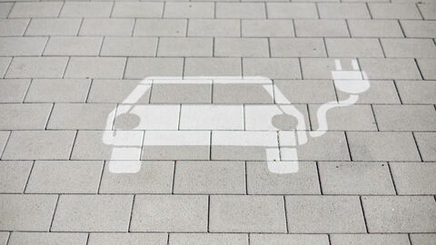 Aufgesprühtes Motiv eines E-Autos auf dem Boden als Hinweis zu einer Stromtankstelle