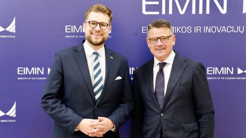 Zwei Männer stehen nebeneinander und geben sich die Hand.