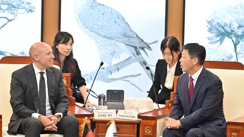 Manfred Pentz sitzt neben Jeong Joo Park - im Hintergrund sitzen zwei Übersetzerinnen.